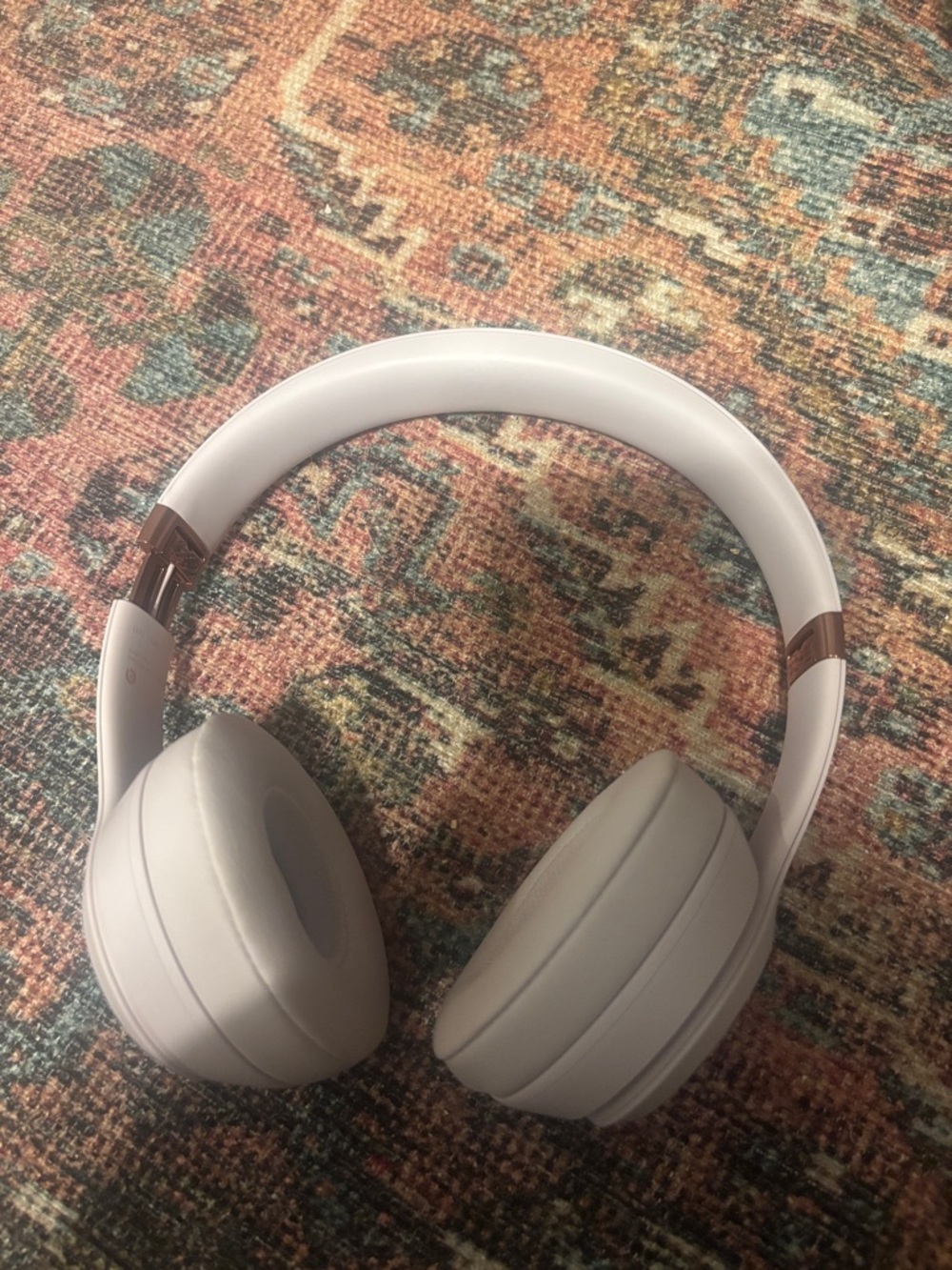 Beats Solo 4 Wireless Over-Ear Headphones in Light Gray with Rose Gold Accents.